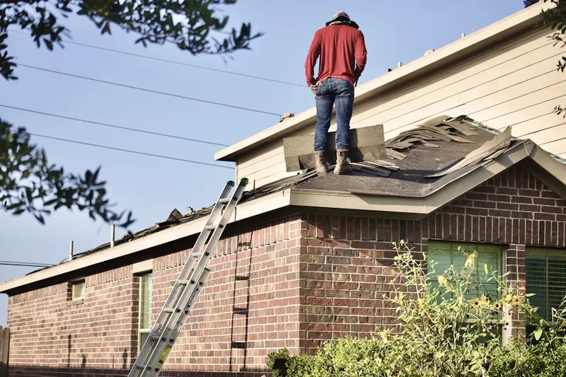 Professional roofer working on a residential roof in Silsbee